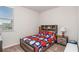 Comfortable bedroom with a sports themed bedset, side table, and window view at 112 Leveret Rd, Locust Grove, GA 30248