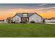 Charming home with a well-kept lawn and professional landscaping, boosting curb appeal at sunset at 112 Leveret Rd, Locust Grove, GA 30248