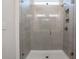 The modern shower has glass doors, gray tile and overhead lighting at 112 Leveret Rd, Locust Grove, GA 30248