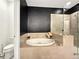 Modern bathroom with soaking tub, glass enclosed shower, neutral tiling, contrasting dark painted walls, and adjacent toilet at 1127 Provence Ln, Decatur, GA 30033