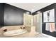 A modern bathroom showcases a large tub and glass enclosed shower with a neutral color palette and a decorative art piece at 1127 Provence Ln, Decatur, GA 30033