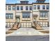 Charming townhomes featuring brick accents, individual garages, and inviting staircases at 1127 Provence Ln, Decatur, GA 30033