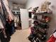 A long walk-in closet featuring wall-mounted shelves for shoes, handbags, and jewelry plus hanging rods for folded garments at 1127 Provence Ln, Decatur, GA 30033