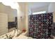Bright bathroom featuring a vanity with a sink and a shower with a colorful patterned curtain at 2209 Cedar Place Ct, Snellville, GA 30078