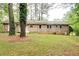 View of home's back exterior, showcasing the yard, mature trees, and a glimpse of the home's architecture at 2621 Manor Pl, Ellenwood, GA 30294
