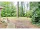 Spacious backyard featuring a patio area and mature trees, perfect for outdoor relaxation and entertainment at 2621 Manor Pl, Ellenwood, GA 30294
