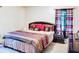 Comfortable bedroom with a queen-sized bed, decorative pillows, and window with colorful curtains at 2621 Manor Pl, Ellenwood, GA 30294