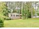 Charming brick home with black shutters and a well-maintained lawn surrounded by mature trees at 2621 Manor Pl, Ellenwood, GA 30294