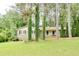 Quaint single-story home featuring a front porch, mature trees, and a well-manicured lawn at 2621 Manor Pl, Ellenwood, GA 30294