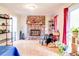 Bright living room with a stone fireplace, hardwood floors, and large windows, creating a warm and inviting space at 2621 Manor Pl, Ellenwood, GA 30294