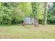 Backyard shed surrounded by mature trees and greenery, offering ample storage space at 2621 Manor Pl, Ellenwood, GA 30294