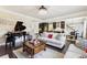 Open-concept living room with hardwood floors, piano, kitchen view, fireplace, and comfortable seating at 2793 Bloom Cir, Dacula, GA 30019
