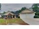 Inviting single Gathering home featuring a two-car garage and manicured front lawn at 1229 Huntington Place Cir, Lithonia, GA 30058