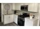 Well-lit kitchen featuring white cabinets, stainless steel appliances, and modern countertops at 2135 Niskey Lake Sw Rd, Atlanta, GA 30331