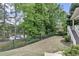 A fenced yard features mature trees, views of the lake, access to the raised back porch, and beautifully maintained landscaping at 2548 Lakeview East Se Trl, Atlanta, GA 30316