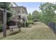A swing set on the lawn near a back porch, with mature trees and a distant pergola and pool at 2548 Lakeview East Se Trl, Atlanta, GA 30316
