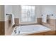 Soaking tub under a frosted window with black hardware, perfect for relaxation at 2548 Lakeview East Se Trl, Atlanta, GA 30316