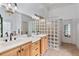 Bright bathroom featuring double vanities, a glass block shower wall, and tiled floors at 2548 Lakeview East Se Trl, Atlanta, GA 30316