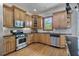 Well-lit kitchen featuring stainless steel appliances, black countertops, and wood cabinets at 2548 Lakeview East Se Trl, Atlanta, GA 30316
