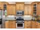 Updated kitchen features stainless appliances, light wood cabinets, stone backsplash, and granite countertops at 2548 Lakeview East Se Trl, Atlanta, GA 30316