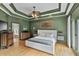A spacious main bedroom featuring a tray ceiling, hardwood floors, and access to the ensuite bathroom at 2548 Lakeview East Se Trl, Atlanta, GA 30316