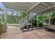 Covered patio with concrete flooring, stairs leading to upper level, and view of the lush backyard at 2548 Lakeview East Se Trl, Atlanta, GA 30316
