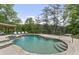 Kidney shaped swimming pool with waterfall feature and lounge chairs overlooking a lake and surrounded by mature trees at 2548 Lakeview East Se Trl, Atlanta, GA 30316