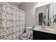 Bathroom with a vanity, a leaf-patterned shower curtain and a mirror with a view of the staircase at 4850 Wilshire Xing, Cumming, GA 30040