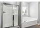 Clean bathroom featuring a glass-enclosed shower, a soaking tub, and a window to provide natural light at 4850 Wilshire Xing, Cumming, GA 30040