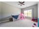 Bright bedroom featuring a crib, play tent, ceiling fan, and natural light from a window at 4850 Wilshire Xing, Cumming, GA 30040