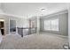 Open loft area with neutral carpet, large window, and elegant railing at 4850 Wilshire Xing, Cumming, GA 30040