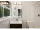Updated bathroom vanity with white fixtures, vanity lights, and a large mirror at 1019 Crestwood Ln, Stone Mountain, GA 30087