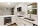 Well-lit kitchen with stainless steel appliances, bright white cabinets, quartz countertops, and a view of the backyard at 1019 Crestwood Ln, Stone Mountain, GA 30087