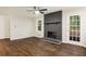 Bright living room with a painted brick fireplace, ceiling fan, wood floors, and access to the backyard at 1019 Crestwood Ln, Stone Mountain, GA 30087
