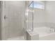 Elegant bathroom featuring a separate shower and soaking tub, complemented by tiled walls and modern fixtures at 1651 Tide Mill Rd, Cumming, GA 30040