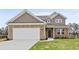 Charming two-story home featuring a brick facade, attached two-car garage and a well-manicured lawn at 1651 Tide Mill Rd, Cumming, GA 30040