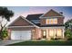 Charming two-story brick home with a manicured lawn, attached two car garage, and covered front porch at 1651 Tide Mill Rd, Cumming, GA 30040