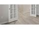 Bright hallway showcasing light gray flooring and white french doors offering a modern and stylish entrance at 1651 Tide Mill Rd, Cumming, GA 30040