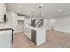 Open-concept kitchen featuring white cabinets, stainless appliances, island with seating and wood-look floors at 1651 Tide Mill Rd, Cumming, GA 30040