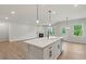 Open concept kitchen and living room featuring an island with a sink, fireplace, and stainless appliances at 1651 Tide Mill Rd, Cumming, GA 30040