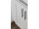 Close-up of white kitchen cabinets featuring modern, minimalist silver handles at 1714 Gunnin Nw Trce # 237, Atlanta, GA 30318