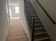 Bright hallway with staircase featuring dark wood steps and modern black iron balusters at 1714 Gunnin Nw Trce # 237, Atlanta, GA 30318