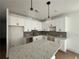 Modern kitchen with white cabinets, gray backsplash, and a large island with quartz countertops at 1714 Gunnin Nw Trce # 237, Atlanta, GA 30318