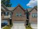 Charming brick townhome featuring a two-car garage and well-maintained landscaping at 221 Irwell Path, Lawrenceville, GA 30044