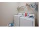 Functional laundry room with washer, dryer, and storage shelf at 221 Irwell Path, Lawrenceville, GA 30044