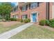 Brick townhome showcasing a blue front door, trimmed bushes, and a concrete walkway at 4101 Dunwoody Club Dr # 49, Atlanta, GA 30350