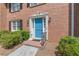 Close-up of a brick townhome entrance with a blue door and manicured landscaping at 4101 Dunwoody Club Dr # 49, Atlanta, GA 30350