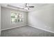 Spacious bedroom featuring a tray ceiling with fan and a large window at 9188 Jefferson Village Sw Dr, Covington, GA 30014