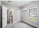 Well-lit bedroom with a window, air conditioner, and a closet for organized storage at 9188 Jefferson Village Sw Dr, Covington, GA 30014