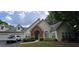 Inviting home with attached garage, brick entryway, manicured lawn and lush landscaping at 1231 Creek Forest Ln, Austell, GA 30106
